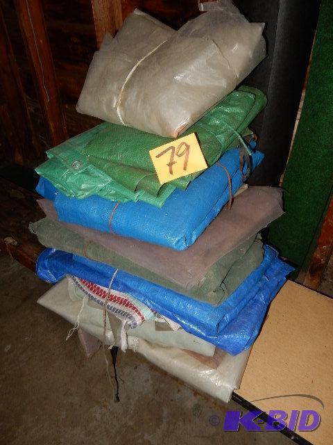 lot 79 image: Pile of tarps,roll tar paper. 3ft wide pies of green walkway