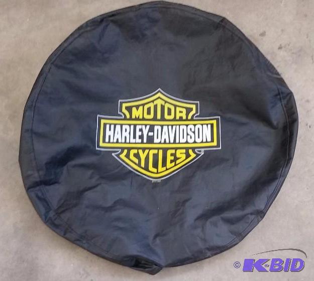 lot 31 image: Harley Davidson. Spare Tire Cover.  Small rips along the elastic.  Does not show or affect Use.