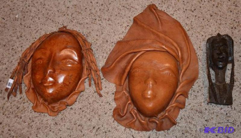 Two Leather life size masks, one wooden carvi...