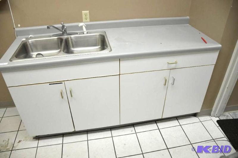 White cabinet with grey countertop and sink. ...