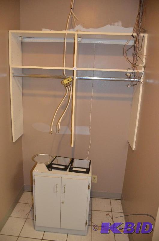 Grey cabinet and wall shelf with towel rack. ...