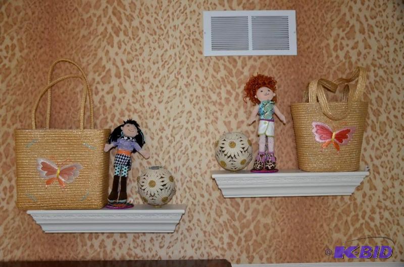 Two white wall mounted shelves with decorativ...