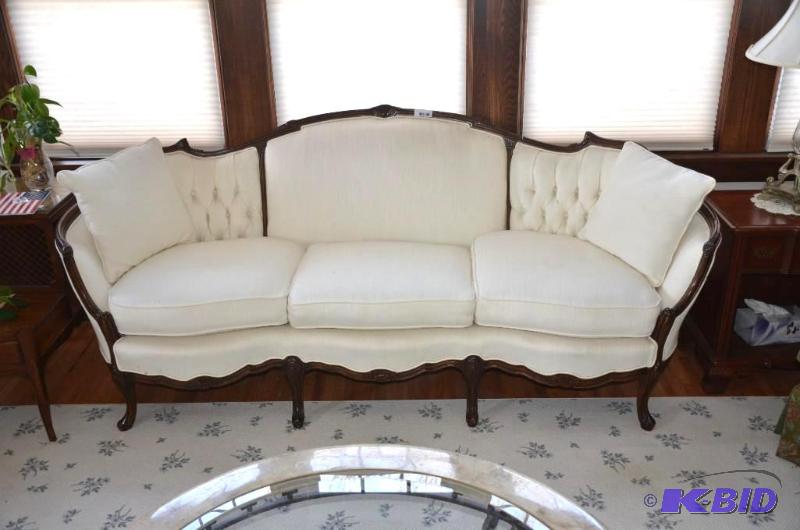 Antique ornately engraved sofa with wood trim...