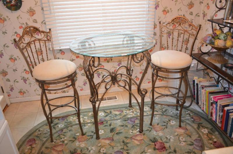 lot 4 image: High glass top kitchen table with two chairs....