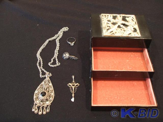 A black laquer jewel box with a sil...
