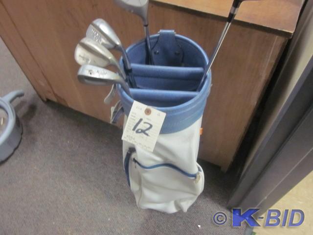 White leather golf bag with clubs. ...